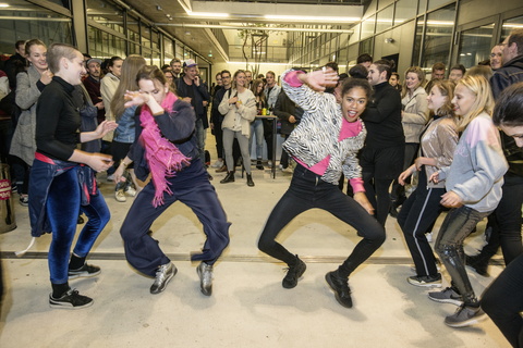 junge Menschen tanzen in einem Pulk von Menschen auf der Stadtterrasse