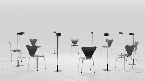 weißer Raum (Boden und Wand) mit einfachen schwarzen Stühlen und Mikrofonen