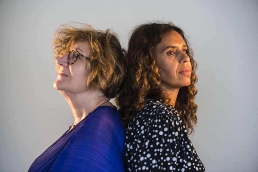 2 Frauen im Profil, sie stehen Rücken an Rücken, eine jünger, die andere etwas älter