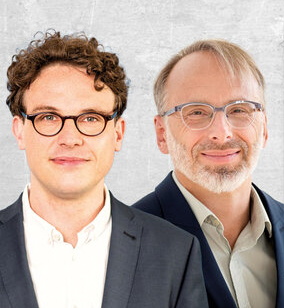 Autorenfoto, zwei Männer im dunklen Jacket und weißem Hemd, beide mit markanter Brille