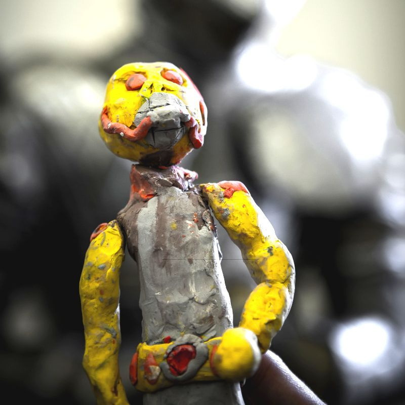 Fimofigur mit grimmigem Blick, gelbe Arme und gelber Kopf und grauer Rumpf