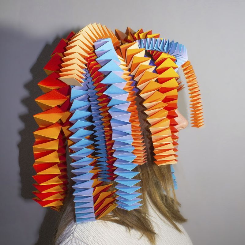 Kopf mit langen Haaren, geschmückt mit Ziehharmoniken aus Papier gefaltet