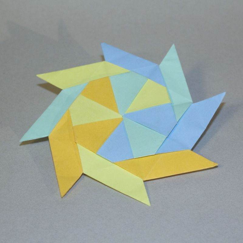 gefalteter Papierstern aus verschieden-farbigem Papier, Pastelltöne, blau, gelb, türkis, orange