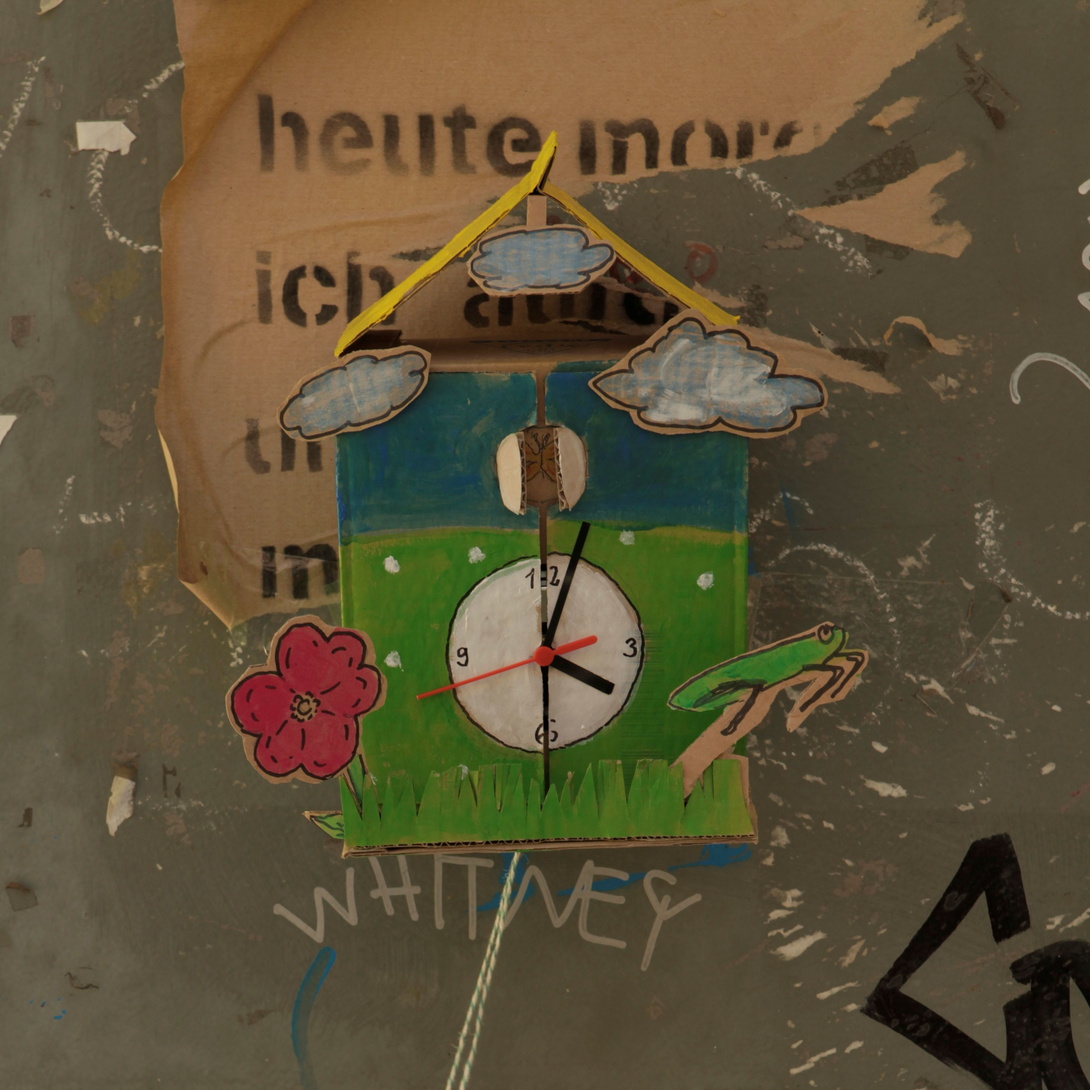 gebastelte, verspielte Kuckucksuhr, angemalt in Grün und Blau mit gelbem Dach