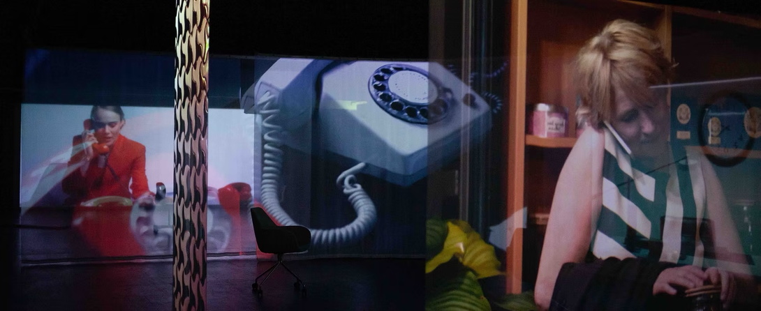 Projektionen, die sich überlappen, jeweils eine Frau an einem Telefon, dazwischen groß ein Wählscheiben-Telefon eingeblendet