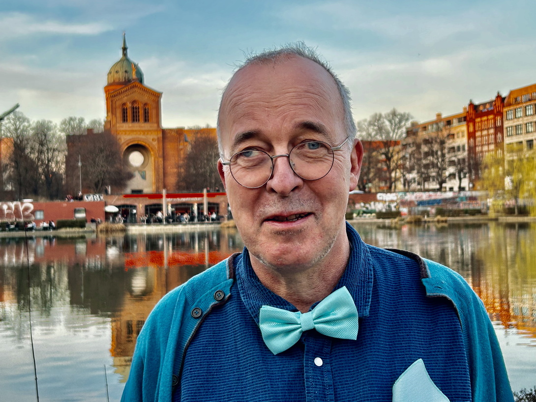 älterer Herr in blauem Hemd mit blauer Fliege vor dem Engelbecken in Berlin
