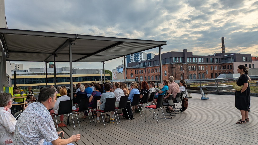 Publikum auf einer Dachterrasse in der Stadt von hinten aufgenommen