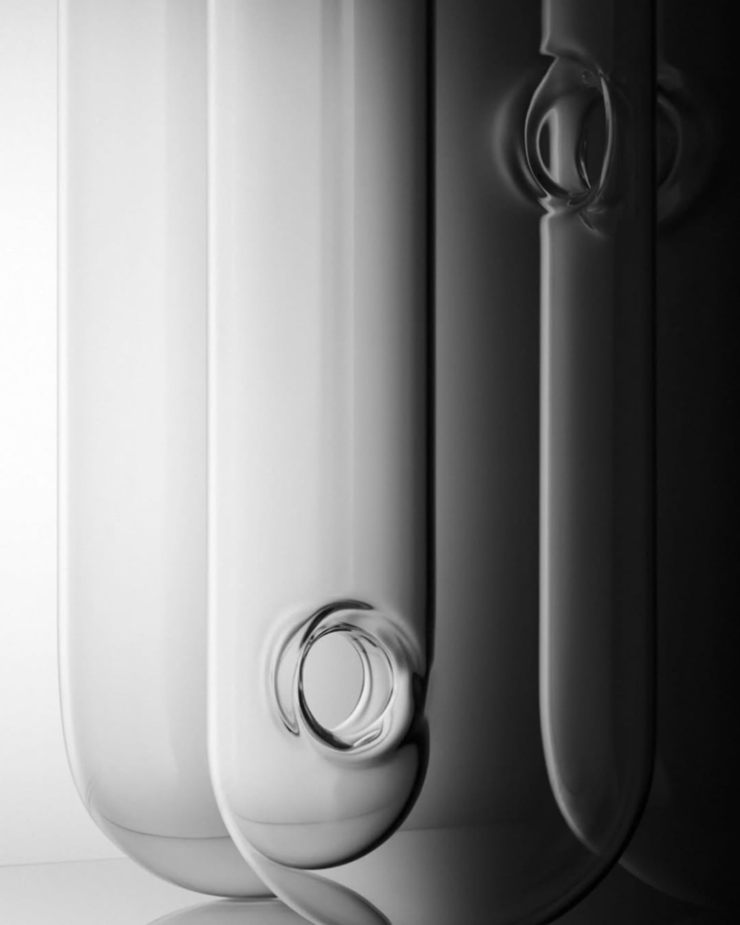 dünne Glasvasen in Reihe hintereinander in Schwarz Weiß fotografiert