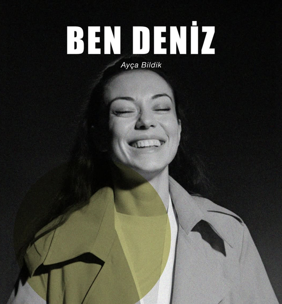 junge Frau in einem Trenchcoat lacht mit geschlossenen Augen, schwarzer Hintergrund, hellgrüner, halbtransparenter Kreis unten links. weiße Lettern Ben Deniz